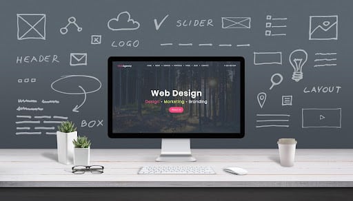 A web designer’s monitor is surrounded by doodles of the different components of web design.